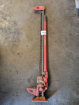 un coupe-tube rouge posé par terre à côté d'un autre coupe-tube