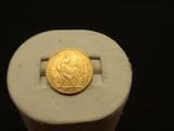 une pièce d'or posée sur un objet blanc