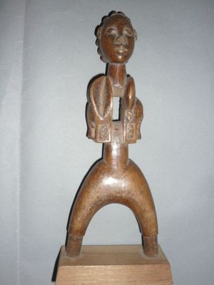 statue représentant un homme assis sur un bloc de bois