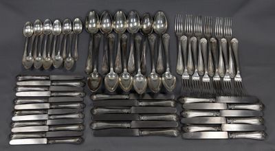 de nombreuses fourchettes et cuillères disposées sur la table
