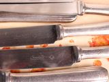 four knives on a cutting board with a knife in the middle