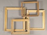 four gold picture frames are arranged on a gray wall