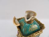 a small blue vase with a gold decoration on it