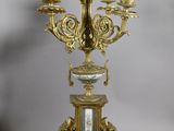 pair of antique brass candlesticks with a clock on each of them