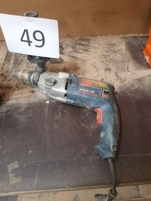 a drill and a sign on the floor in a room