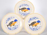 trois assiettes garnies de poisson posées sur une table