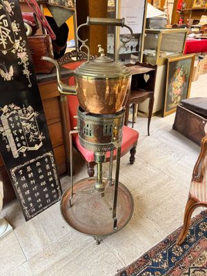 a large copper pot sitting on a stand in a room