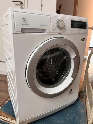 a white washing machine sitting on top of a blue chair
