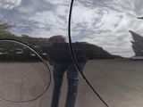 a reflection of a man standing in the reflection of a car door