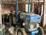 a blue tractor that is parked in a garage
