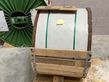 un tonneau en bois posé sur une palette, à côté d'une roue verte