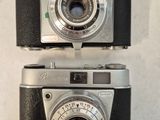 two old cameras sitting side by side on a table