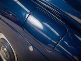 a close up of a blue car parked on the side of the road
