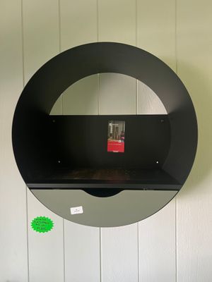 une étagère noire surmontée d'un miroir accroché au mur