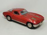 une petite voiture rouge posée sur une surface blanche