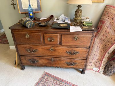 une commode sur laquelle est posée une lampe, dans une pièce