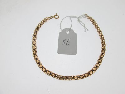 gros plan d'un bracelet en chaîne en or avec une étiquette de prix