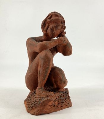 a statue of a woman sitting on top of a rock