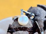 a white pearl ring sitting on top of a piece of chocolate