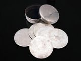 a pile of silver coins sitting on a black surface