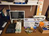 a desk with a monitor, keyboard, printer, and other items on it