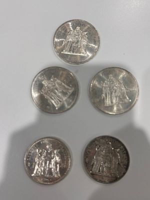 four different types of coins sitting on top of a white surface