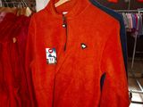 a red jacket hanging on a clothes rack in a room