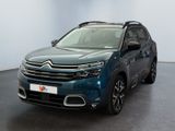 La Citroën bleue est garée dans une pièce au sol noir.