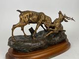 statue représentant un cerf et une biche posés sur un rocher, sur fond blanc