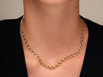 a close up of a woman wearing a black shirt and a gold chain necklace