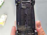 a person holding a black toy car in their hand