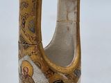 a small vase with a gold decoration on it