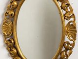 un gros plan d'un miroir accroché au mur, avec un mur blanc en arrière-plan