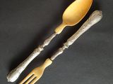 two forks and spoons are sitting on a black surface