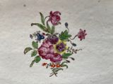 a plate with flowers painted on it on a table