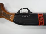 an old gun with a red ribbon on it sitting on a white surface