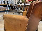 brown leather chair with riveted arms in a workshop area