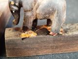 a small wooden elephant that is standing on a piece of wood
