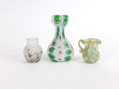 trois vases posés l'un à côté de l'autre sur une surface blanche