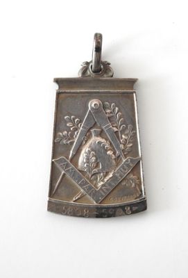 un pendentif en argent sur lequel figure le portrait d'un homme