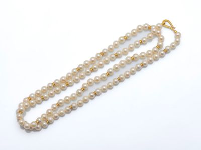 un collier de perles à un rang avec un fermoir en or sur fond blanc