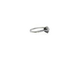 a ring with a black diamond on it on a white surface