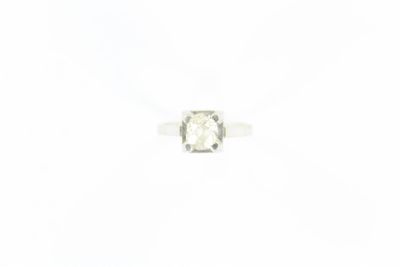 un gros plan d'une bague sertie d'un diamant blanc sur une surface blanche