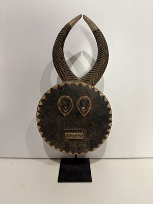 an image of a wooden mask with horns on a stand