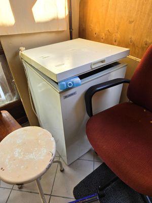 une petite table avec une chaise à côté d'un petit réfrigérateur