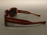 brown sunglasses with black lenses on a table with a white background