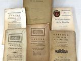 several old books sitting on top of each other on a table