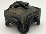 une petite boîte en bronze surmontée d'un lézard
