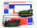two toy trains sitting next to each other on a white surface