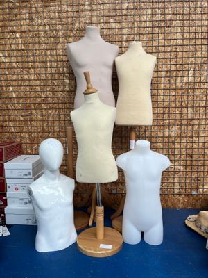 trois mannequins assis sur une table bleue